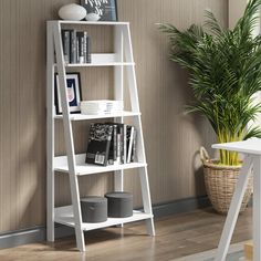 a white leaning book shelf with books on it