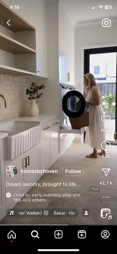 a woman standing in a kitchen next to a window with the app on it's screen