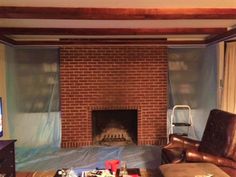 a living room filled with furniture and a fire place in front of a brick fireplace