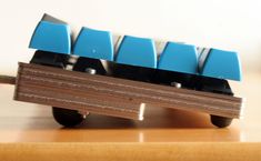 a toy truck with four blue seats on it's back wheels sitting on a wooden table