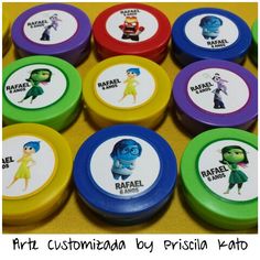 there are many small round magnets with cartoon characters on them, all in different colors