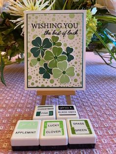 some cards are sitting on a table with flowers and greenery in the back ground