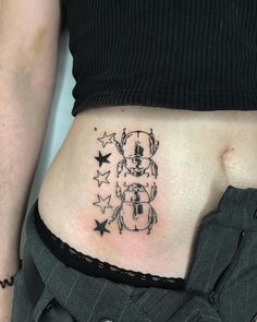 a woman's stomach with a small tattoo on her belly and stars around it