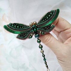 a green beaded dragonfly brooch with pearls and beads on it's wings