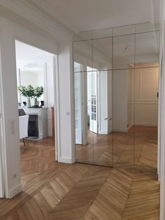 an empty room with wooden floors and mirrors on the wall, in front of a desk