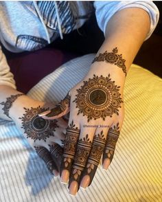 a woman's hand with henna tattoos on it