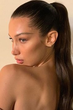 a woman with very long hair wearing a white towel and looking off to the side