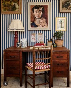 a desk with a chair and painting on the wall