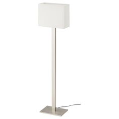 a white floor lamp with a square shade on it's base and a cord plugged in