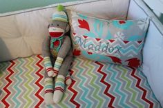 a stuffed monkey sitting on top of a bed next to a pillow and pillow case