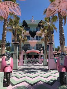 pink scooters parked in front of a building with palm trees