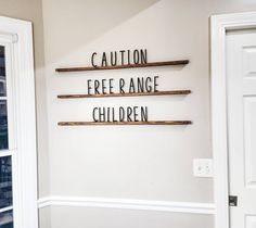 there are three wooden shelves on the wall with words written in them and one is reading caution, free range children