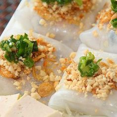 several dumplings with various toppings sitting on a plate