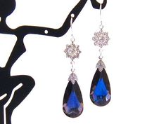 Get noticed wearing these brilliantly sparkling blue crystal dangle earrings.  I used MaliBlue Swarovski teardrop crystals, paired with clear Swarovski  crystal flowers.  The ensemble hangs from  sterling silver ear wires.  Simply Beautiful! Length:  2.3 inches from the top of the wire Additional CUSTOM colors available (MaliBlue shown). Please make your selection at checkout. Also available in 14 CARAT GOLD FILL ear wire Coordinating necklace available here: https://www.etsy.com/listing/186034532/ Arrives with a Marty White card in a lovely decorative bag and bubble wrap packaging. Brides - Please convo me if you need additional necklaces or earrings for your bridesmaids gifts. Discounts are offered for at least 6 or more items totaling at least $250 on a single order not counting shippin Royal Blue Necklace, Dark Blue Wedding, Blue Bridal Earrings, Blue Jewelry Set, Blue Wedding Jewelry, Blue Crystal Necklace, Blue Crystal Earrings, Blue Bridal, Crystal Dangle Earrings