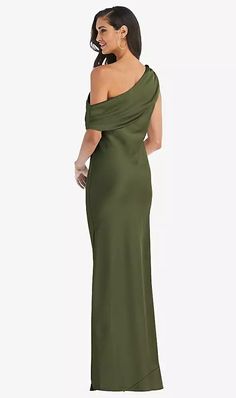 a woman in a long green dress with one shoulder draped over her shoulders and an open back