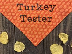 an orange bandana with the words turkey tester written on it and leaves around it