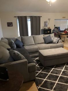 a living room filled with furniture and a large rug on top of a hard wood floor