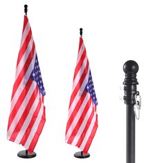 two american flags on black poles next to an umbrella pole with one flag in the wind