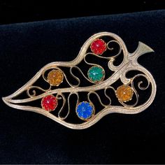 Vintage Schiaparelli Multi-Color Art Glass Cabs Gold-Plated Leaf Brooch 3.75" Set With Emerald, Ruby, Sapphire And Amber Cabochons In Dog-Tooth Prongs, 6 Pretty Glass Cabochon Stones Sprinkled Onto The Golden Leaf Outline Gold-Plating Is In Wonderful Condition, Shows Very Little Evidence Of Wear. Leaf And Stem Are Textured, Adding A Nice Realistic Visual Impact Pin Mechanism Works Well From The 1940's, Will Look Fab On Your Wide Shouldered Blazer Or Jacket "Schiaparelli" In Script On Oval Cartouche Schiaparelli's Designs Celebrated Surrealism And Eccentric Fashion. Her Collections Were Famous For Unconventional And Artistic Themes Like The Human Body, Insects, Or Trompe-L'il, And For T Schiaparelli Necklace, Schiaparelli Vintage Jewelry, Schiaparelli Details, Schiaparelli 1930s Surrealism, Vintage Schiaparelli, Eccentric Fashion, Schiaparelli Jewelry 2022, Leaf Outline, Golden Leaf