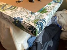 the table is covered with clothes and other items