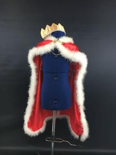 a blue and red coat with gold crown on it's head, sitting on a metal stand