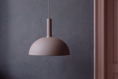 a grey lamp hanging from the ceiling in a room with blue walls and flooring