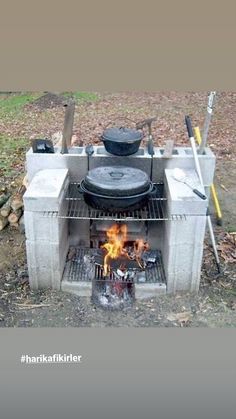 an outdoor oven with cooking utensils on the outside and fire in the inside