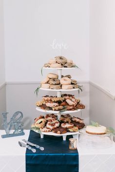 a table topped with three tiered plates filled with donuts and other desserts