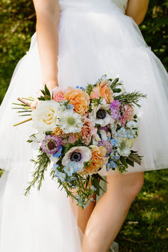 A Girl Holding A Flower Bouquet In Her Hand.