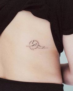 a woman's stomach with a small mountain tattoo on her left side ribcage