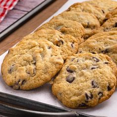 chocolate chip cookies sitting on top of a piece of paper next to a spatula