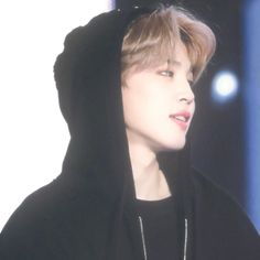 a young man wearing a black hoodie looking off to the side