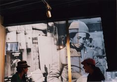 two people sitting in front of a large photo