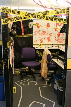 an office cubicle with yellow caution tape on the walls and purple chair in front