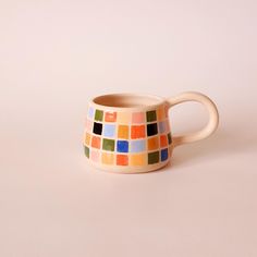 a multicolored ceramic mug sitting on top of a table