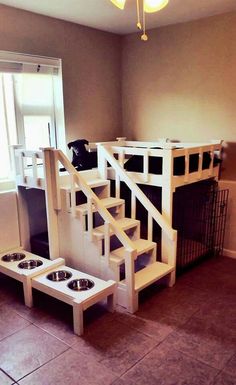 a dog house made out of pallets with stairs and food bowls on the floor