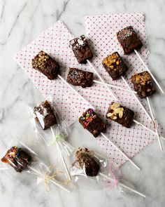 chocolate brownies and marshmallows are on the table next to candy sticks