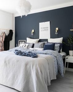 a bedroom with blue walls and white furniture