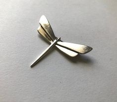 This handsome sterling silver pin was handmade in the 1970's. The pin is designed in the form of a stylized dragonfly. It is stamped on the backside 925, and signed SUE B.,and has the standard pin back clasp. This sleek and light bug has remained in great vintage condition, and is free of any damages such as dents, scratches, stains, cracks , loose or missing parts. Its small size and light weight make it an ideal accessory to pin onto almost any fabric, or cluster with other winged friends. 1.7 Silverware Art, Dragonfly Pin, Silver Pin, Pin Backs, Soldering, Beautiful Packaging, Brooch Pin, Brooches, Etsy Gift Card