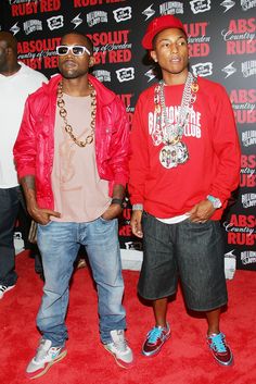 two young men standing next to each other on a red carpet