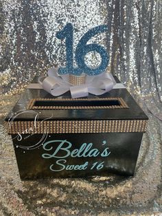 a black and gold box with the number sixteen on it is surrounded by silver sequins