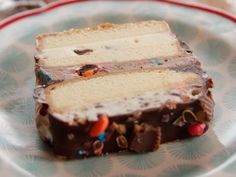 a piece of cake sitting on top of a blue and white plate covered in candy