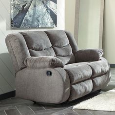 a reclining chair in a living room with a rug on the floor next to it