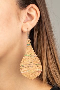 a close up of a person wearing earrings with cork and metal details on the ear