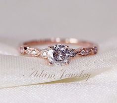 a close up view of a diamond ring on top of a white cloth with the background