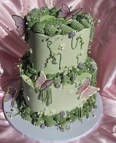 a three tiered green cake with butterflies on it