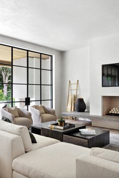 a living room filled with furniture and a flat screen tv mounted on the wall above a fireplace