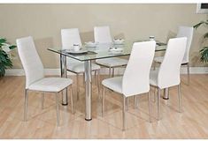 a glass dining table with white chairs around it