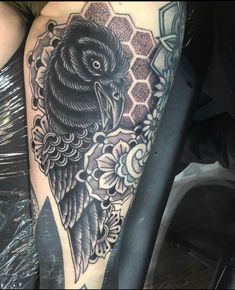 a black and white tattoo on the leg of a woman with an owl in it