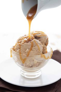 an ice cream sundae is being drizzled with caramel